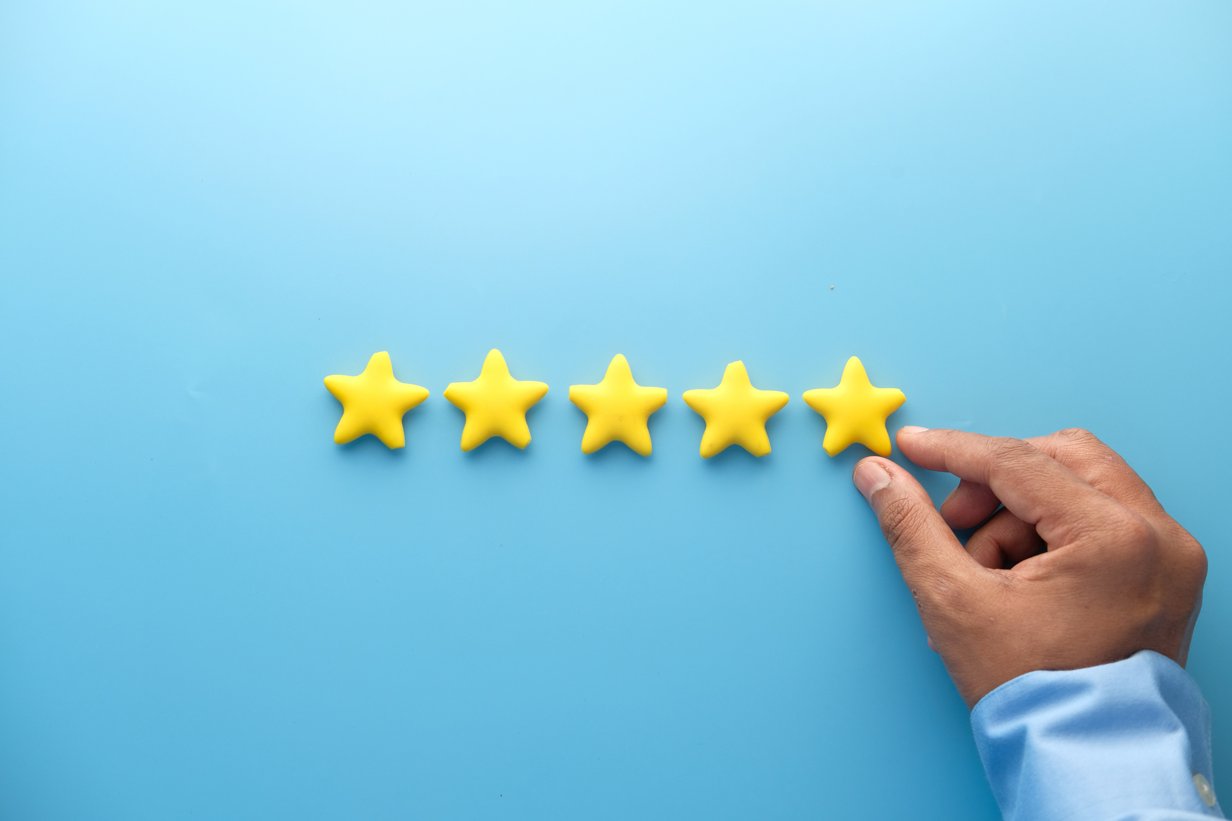 Customer Review Concept. Rating Golden Stars on Blue Background